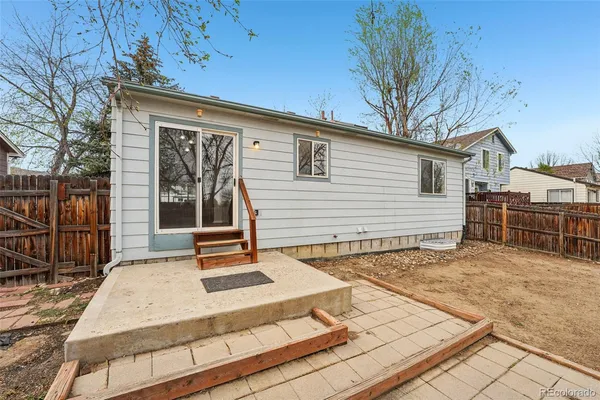 a backyard of a house with barbeque oven and wooden fence