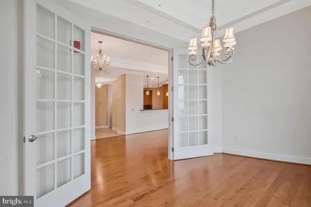 a view of a hallway with wooden floor and chandelier