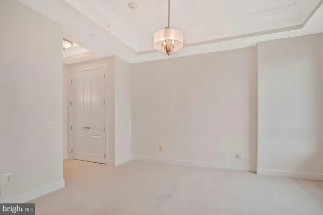 a view of an empty room and chandelier fan