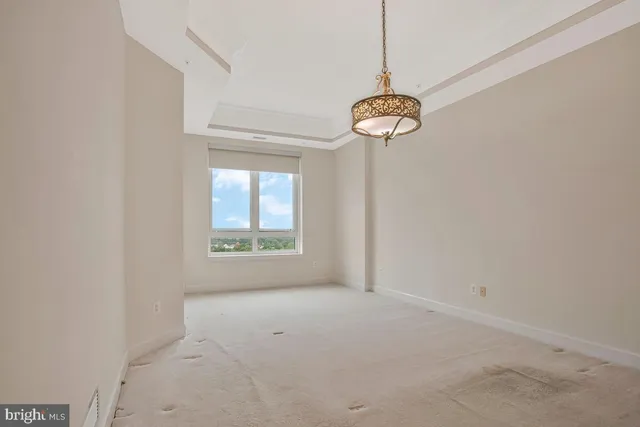 a view of a room with a chandelier fan and windows