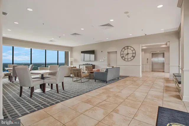 a living room with lots of furniture a rug and white walls