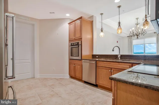 a kitchen with stainless steel appliances granite countertop a sink and a refrigerator