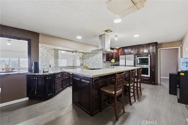 a kitchen with a stove a refrigerator and wooden cabinets