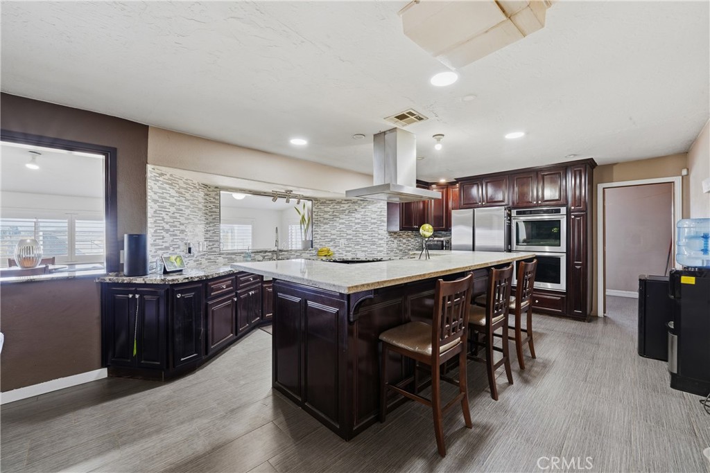 10080 Deep Creek Road Apple Valley, CA 92308 - Photo 12 of 36 a kitchen with a stove a refrigerator and wooden cabinets