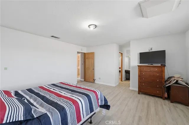 a bedroom with a bed and a flat tv screen on the dresser