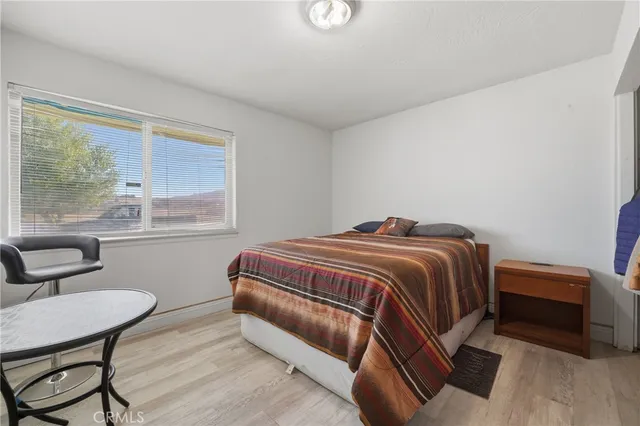 a bedroom with a bed chair and window