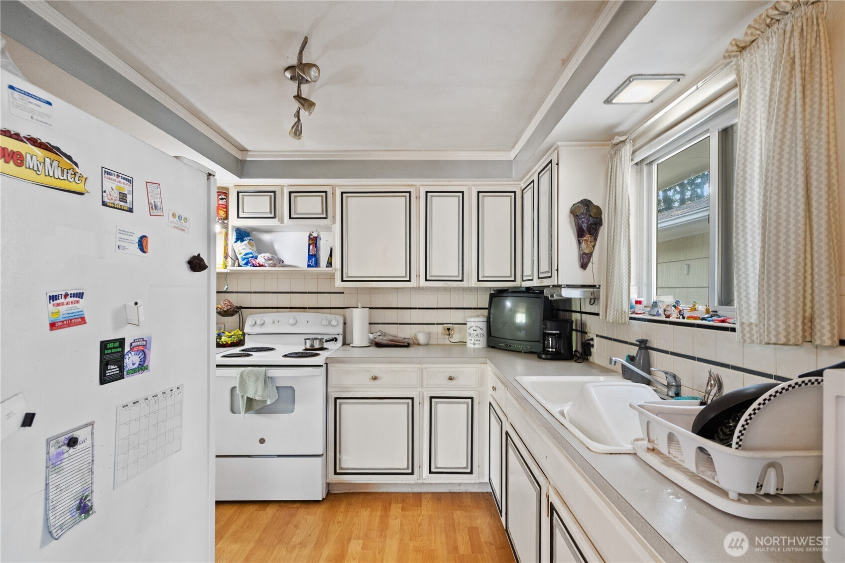105 Northeast 180th Street Shoreline, WA 98155 - Photo 3 of 34 a kitchen with a sink dishwasher a stove and a refrigerator with wooden floor
