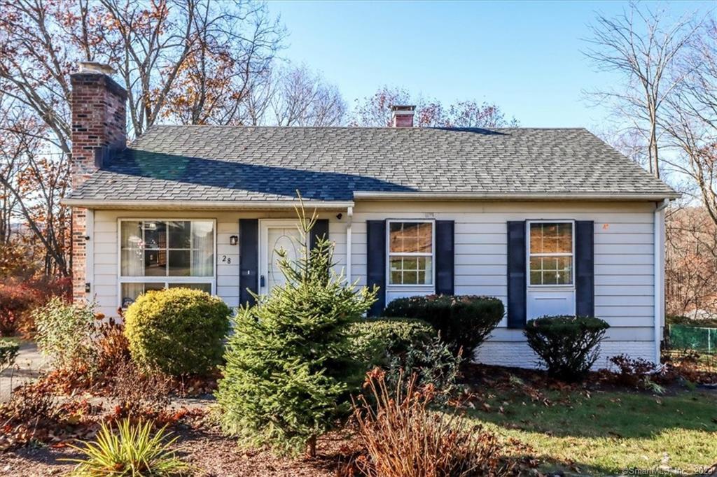 a front view of a house with garden and plants