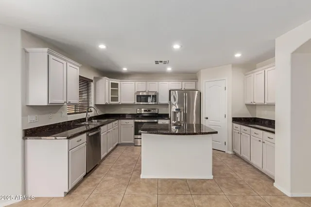 a kitchen with granite countertop a sink stainless steel appliances and cabinets