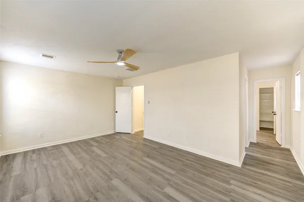 a view of an empty room with wooden floor