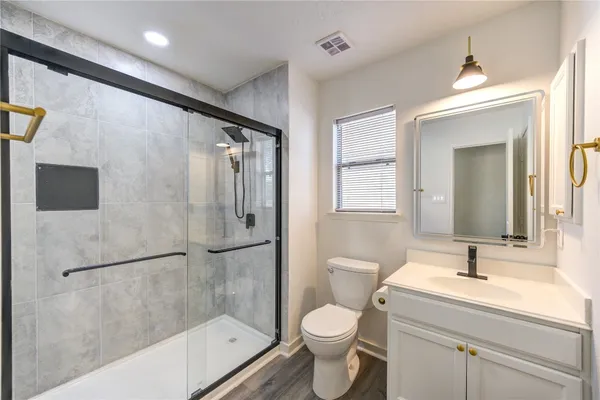 a bathroom with a granite countertop sink toilet and shower