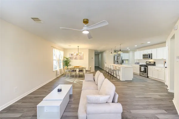 a living room with furniture and a view of kitchen