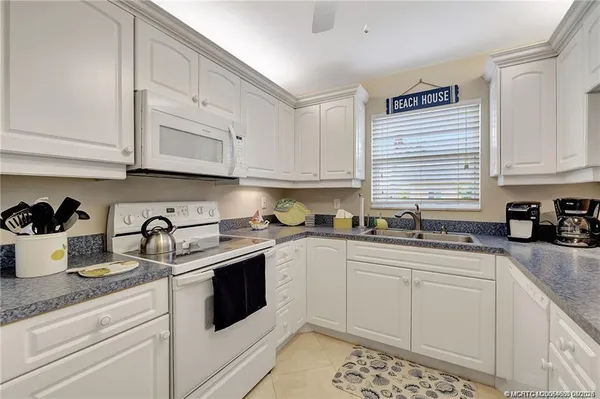 a kitchen with sink cabinets and appliances
