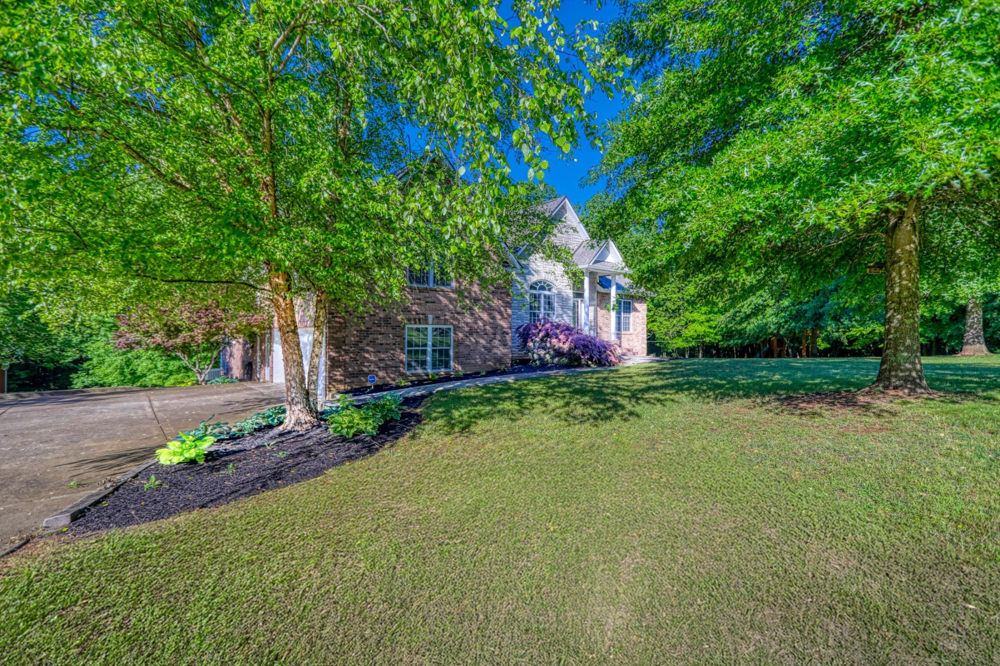 358 Spring Valley Drive Cottontown, TN 37048 - Photo 61 of 67 a front view of a house with a yard and a garden