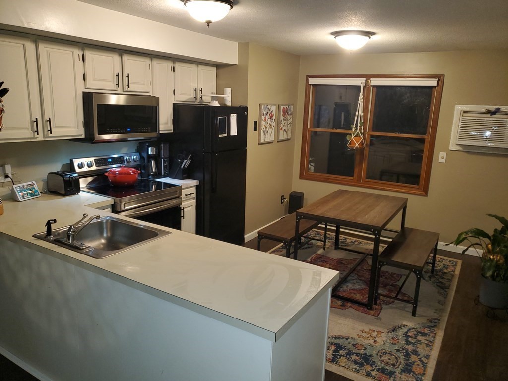 149 Dale Street, Unit S Chicopee, MA 01020 - Photo 4 of 21 a kitchen with stainless steel appliances a microwave a sink and refrigerator