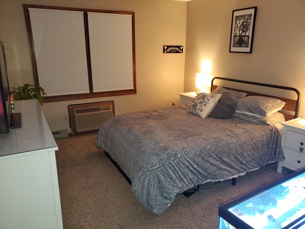 149 Dale Street, Unit S Chicopee, MA 01020 - Photo 9 of 21 a bedroom with a bed and a flat tv screen on the dresser