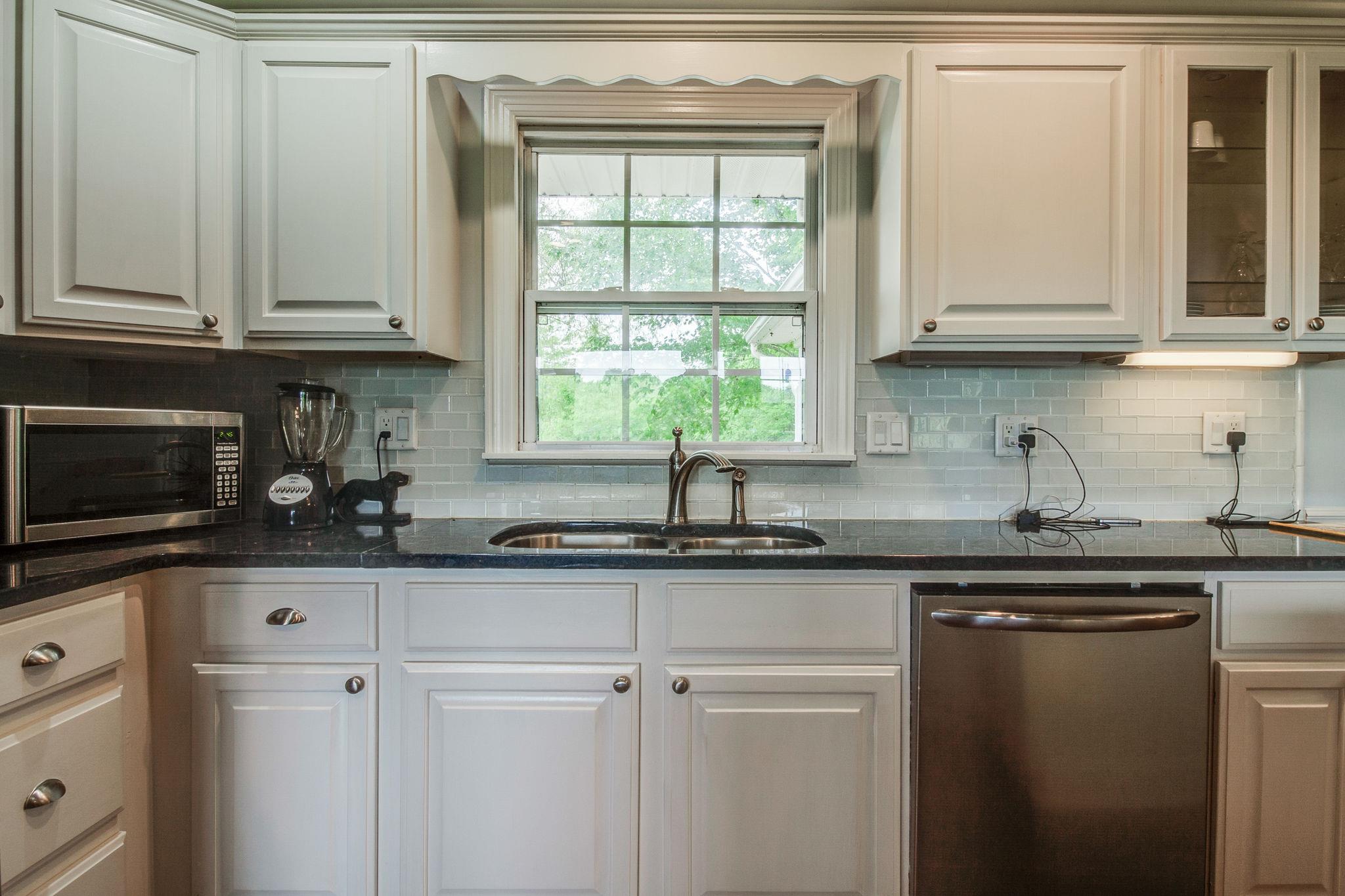 550 Kelley Road Prospect, TN 38477 - Photo 11 of 30 a kitchen with granite countertop white cabinets and a window