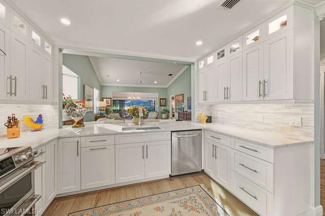 254 Edgemere Way East Naples, FL 34105 - Photo 14 of 41 Kitchen with glass insert cabinets, white cabinets, tasteful backsplash, recessed lighting, and lofted ceiling
