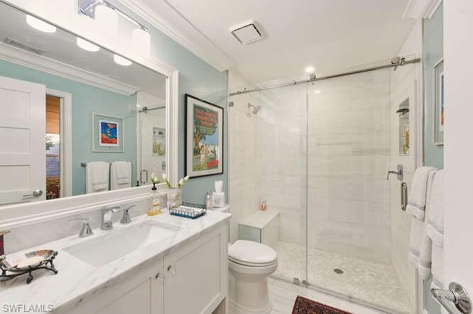 254 Edgemere Way East Naples, FL 34105 - Photo 24 of 41 Full bathroom featuring a shower stall, vanity, and crown molding