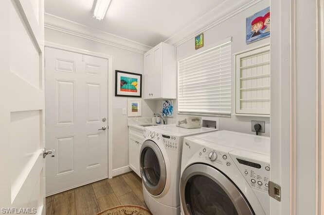 254 Edgemere Way East Naples, FL 34105 - Photo 25 of 41 Laundry room featuring ornamental molding, dark wood finished floors, independent washer and dryer, and cabinet space