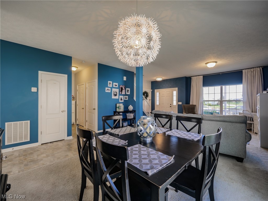 37571 Amber Way North Ridgeville, OH 44039 - Photo 5 of 35 Dining room featuring light carpet and an inviting chandelier