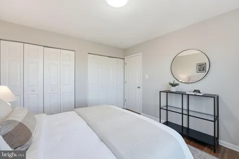 a bedroom with a bed a mirror and a chandelier