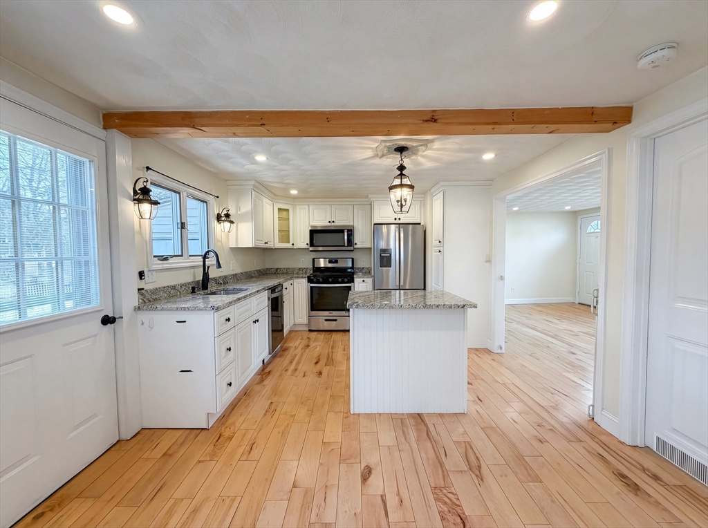 125 Burnham Road Lowell, MA 01852 - Photo 2 of 19 a large kitchen with stainless steel appliances kitchen island a large counter top and a wooden floors