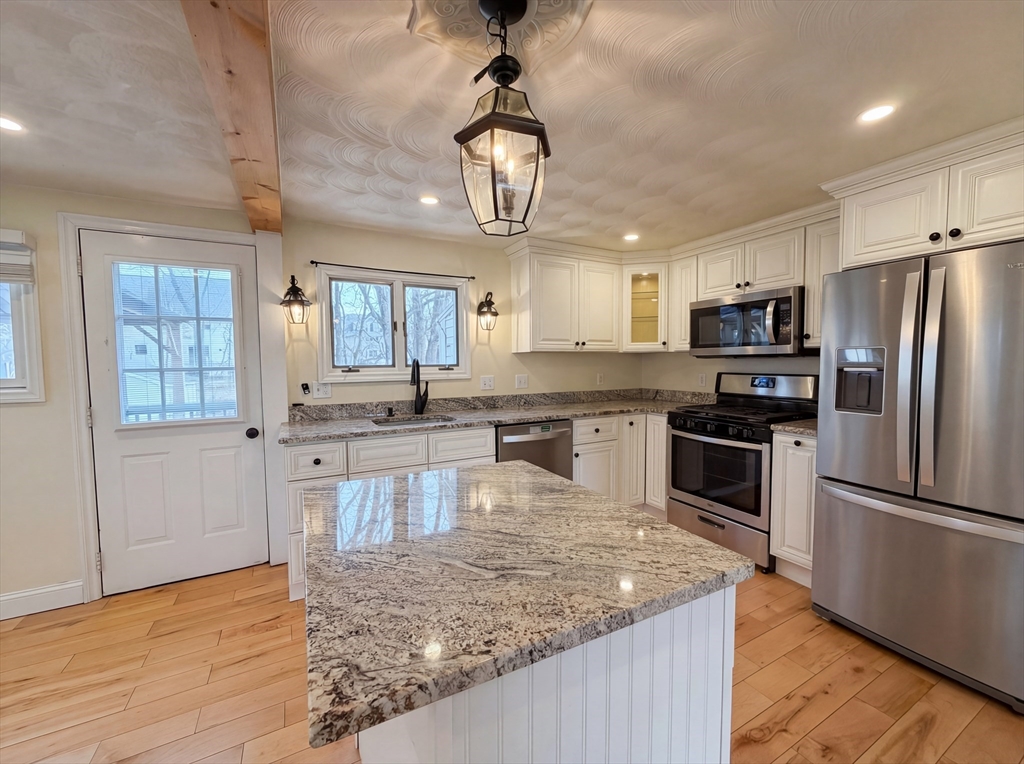 125 Burnham Road Lowell, MA 01852 - Photo 10 of 19 a kitchen with stainless steel appliances granite countertop a sink refrigerator and microwave