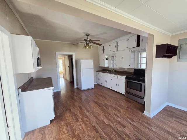 a kitchen with granite countertop a refrigerator and a sink