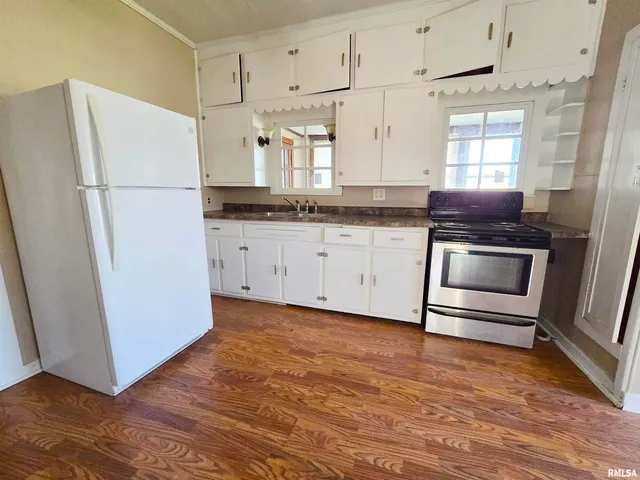 a kitchen with wooden floors and appliances