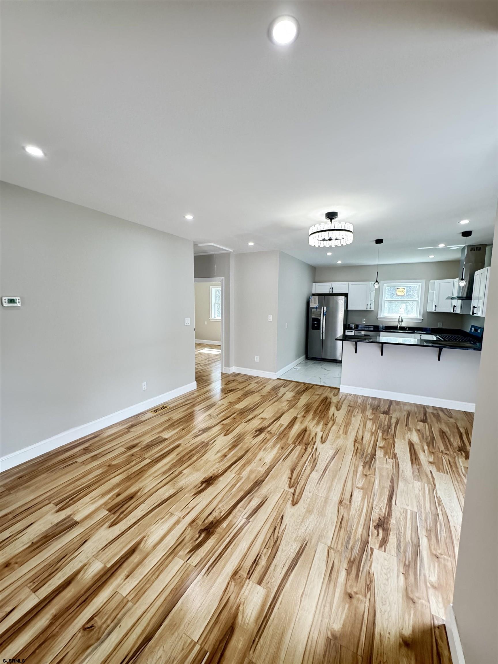 172 Old Port Republic Road Galloway Township, NJ 08205 - Photo 12 of 35 a view of a kitchen with kitchen island a sink wooden floor and a living room view