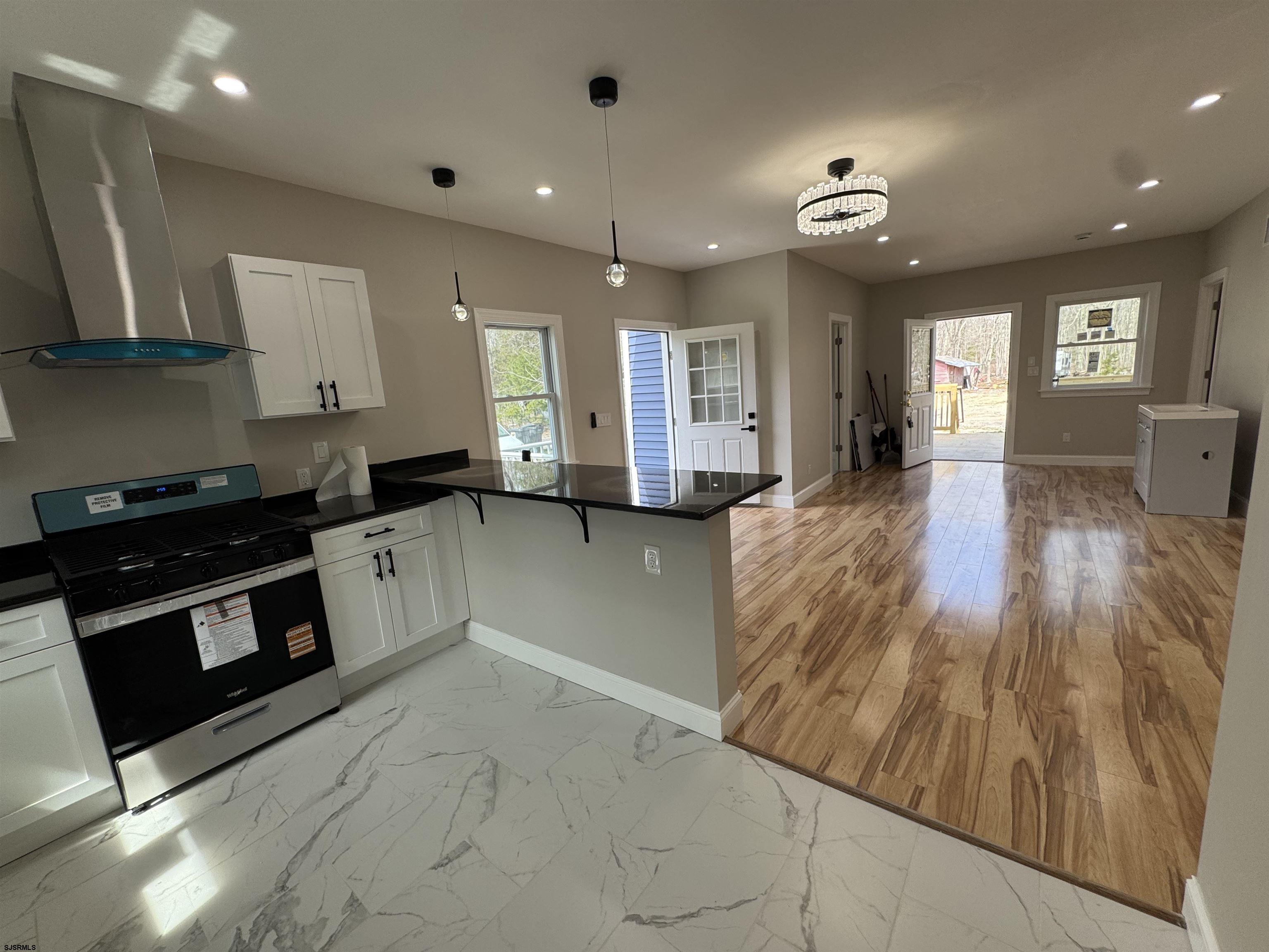 172 Old Port Republic Road Galloway Township, NJ 08205 - Photo 17 of 35 a large kitchen with stainless steel appliances granite countertop a stove and a wooden floors