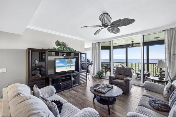 a living room with furniture a ceiling fan and a flat screen tv