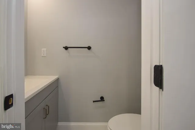 a bathroom with a granite countertop toilet and a sink