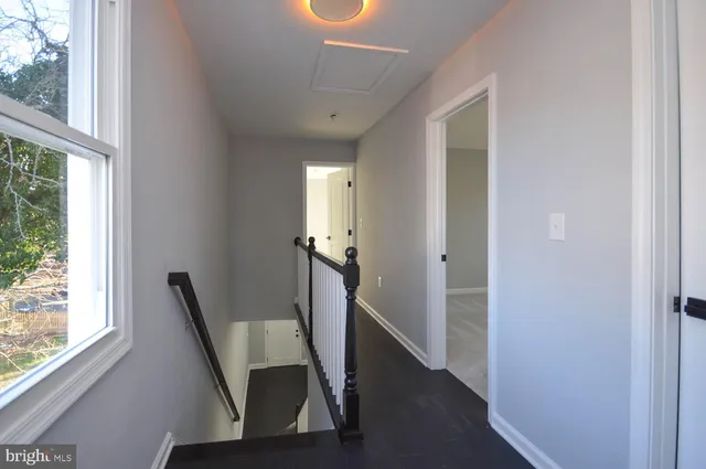 a view of a hallway with furniture and a window