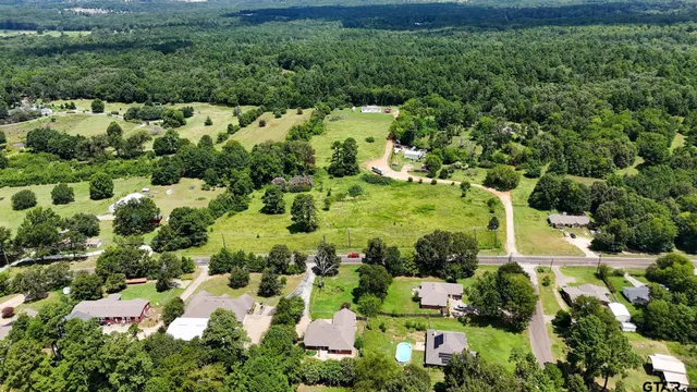 an aerial view of residential house with outdoor space and trees all around