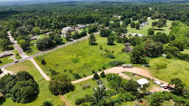 an aerial view of residential house with outdoor space and trees all around