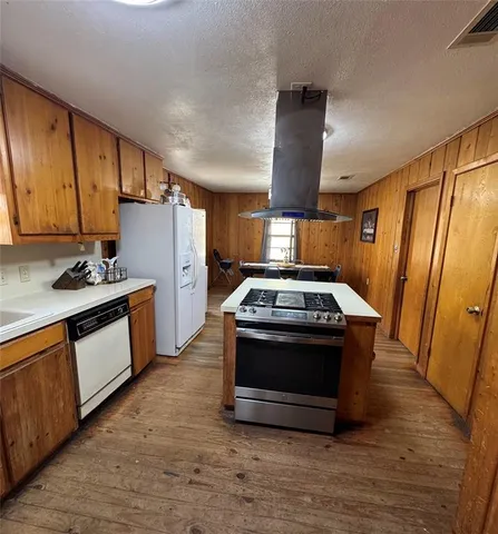 a kitchen with stainless steel appliances wooden cabinets and a stove top oven