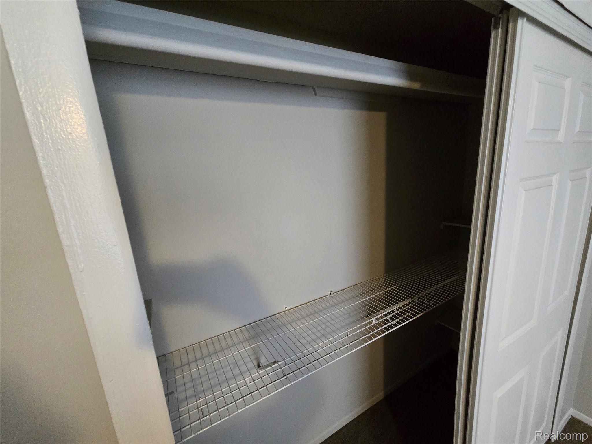 27780 Reo Road Grosse Ile, MI 48138 - Photo 11 of 18 Closet featuring white bi-fold doors, upper storage shelf, and wire shelving system
