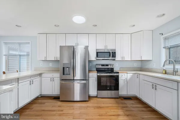 a view of kitchen with wooden floor and electronic appliances