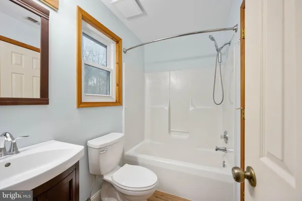 a white toilet sitting next to a bathroom sink and tub