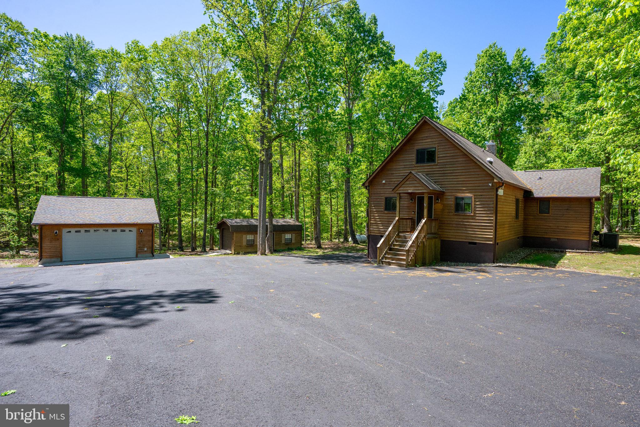 10706 Ropers Run Bumpass, VA 23024 - Photo 61 of 76 a front view of a house with a yard and garage