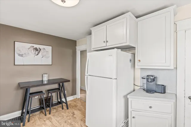 a white kitchen with sink a table and chairs