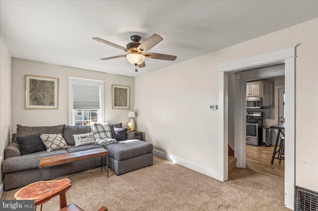 a living room with furniture and a ceiling fan