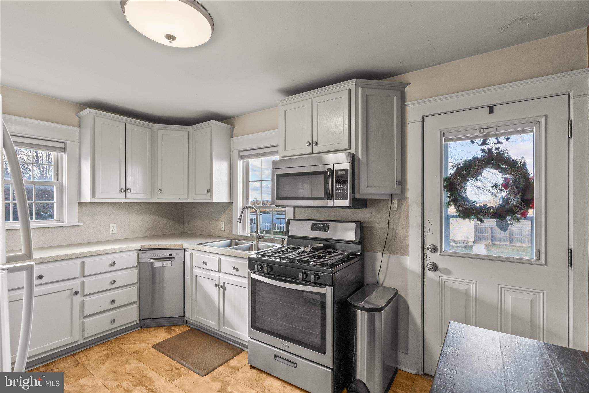 2960 Hanover Pike Hanover, PA 17331 - Photo 8 of 38 a kitchen with stainless steel appliances granite countertop a stove top oven a sink dishwasher and white cabinets with wooden floor
