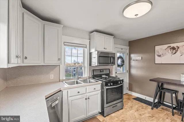 a kitchen with stainless steel appliances a stove a sink and a refrigerator