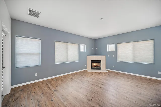 a view of a room with wooden floor chandelier and windows