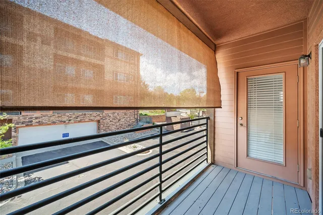 a view of a balcony with wooden floor and fence