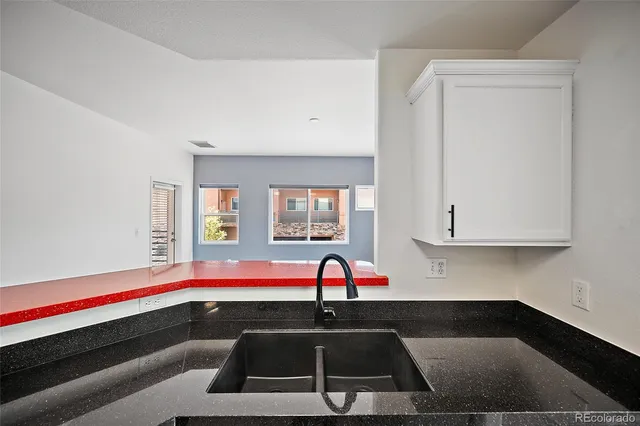 a living room with stainless steel appliances kitchen island a fireplace wooden floor and a fireplace