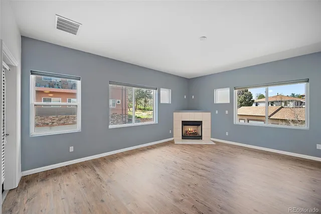 a living room with furniture a fireplace and a large window